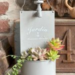 Une composition végétale de plantes succulentes avec un pot en métal gris, inscription Jardin, à poser ou à suspendre