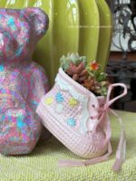 Composition végétale de plantes succulentes avec un chausson en céramique rose, motif à carreau et fleuri