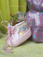 Composition végétale de plantes succulentes avec un chausson en céramique rose, motif à carreau et fleuri