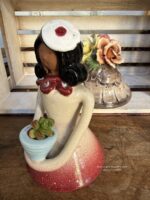 Composition végétale de plantes succulentes avec une statuette femme en terre tenant un pot