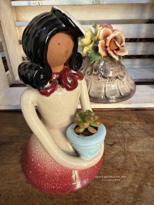 Composition végétale de plantes succulentes avec une statuette femme en terre tenant un pot